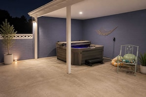 A covered patio area with a hot tub, a chair, and a potted plant. - Modern 2BR with Pool & Near Phoenix Raceway (Avondale)
