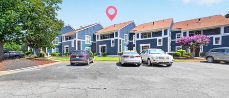 A row of townhouses with a parking lot in front.