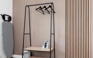 Ein Zimmer mit einem Metallschrank, einem gemusterten Vorhang und einer vertikalen Holzwand.