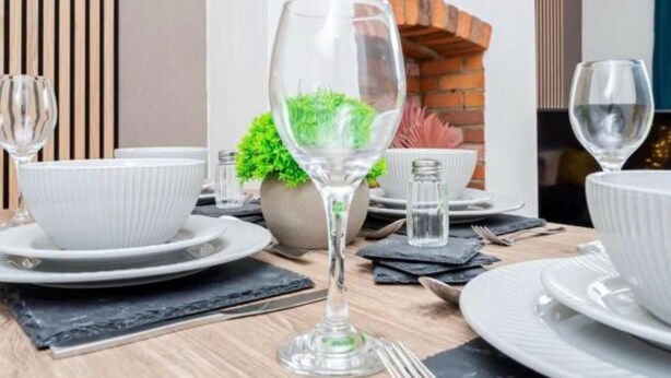 A dining table set with white plates, bowls, and a wine glass. - NEW 3BR Stylish Home Near NEC | HS2 | JLR | Resorts World & B'ham Airport (Birmingham)