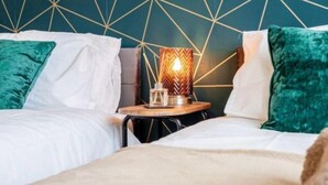 A hotel room with two beds, a geometric wall design, and a table with a lamp. - NEW 3BR Stylish Home Near NEC | HS2 | JLR | Resorts World & B'ham Airport (Birmingham)