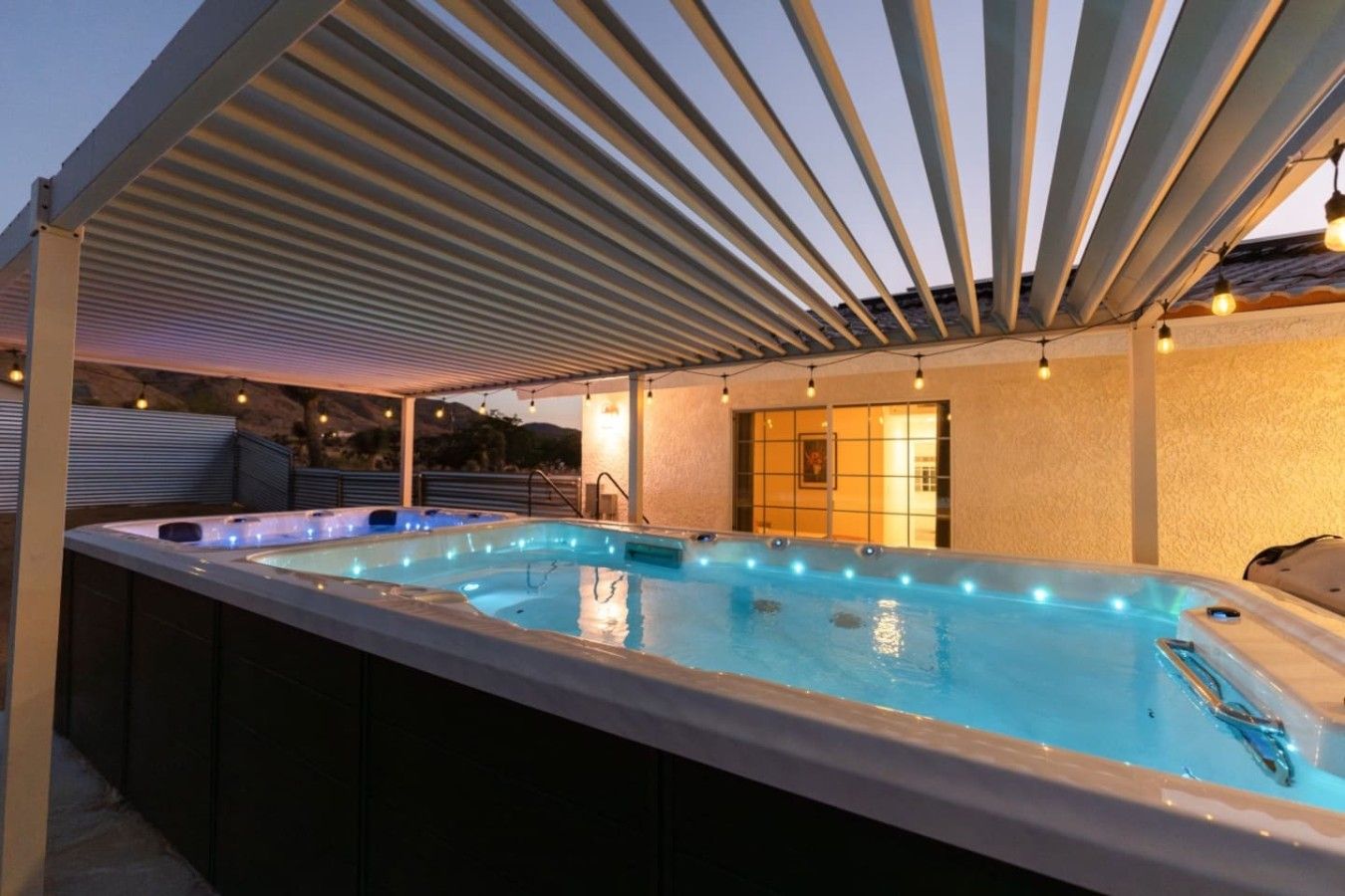 Un área de hidromasaje al aire libre con un pérgola cubierta, un espacio para sentarse y vistas del paisaje.