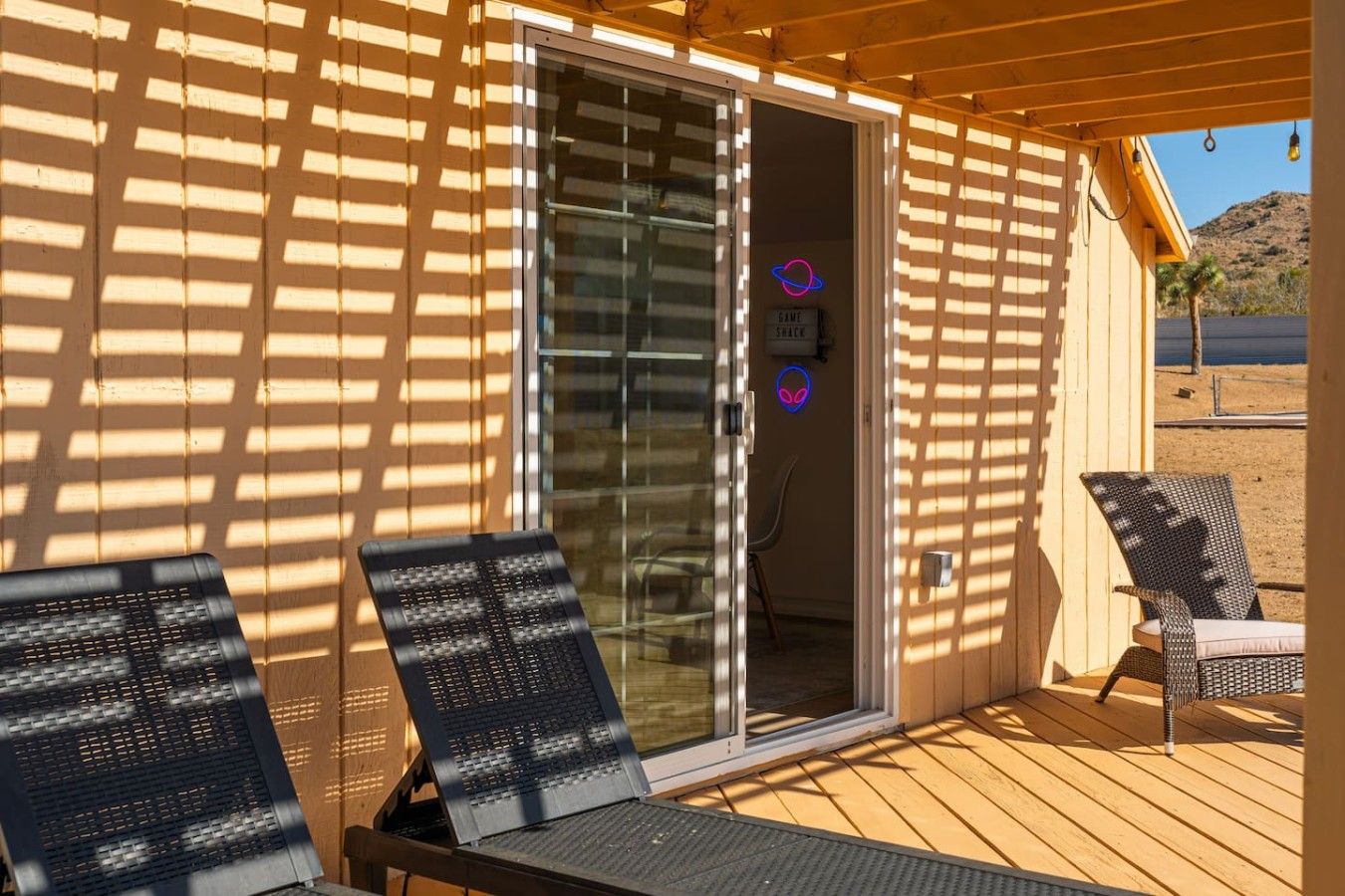 Ein Außenbereich zum Sitzen mit zwei Liegestühlen und einer Holzterrasse.