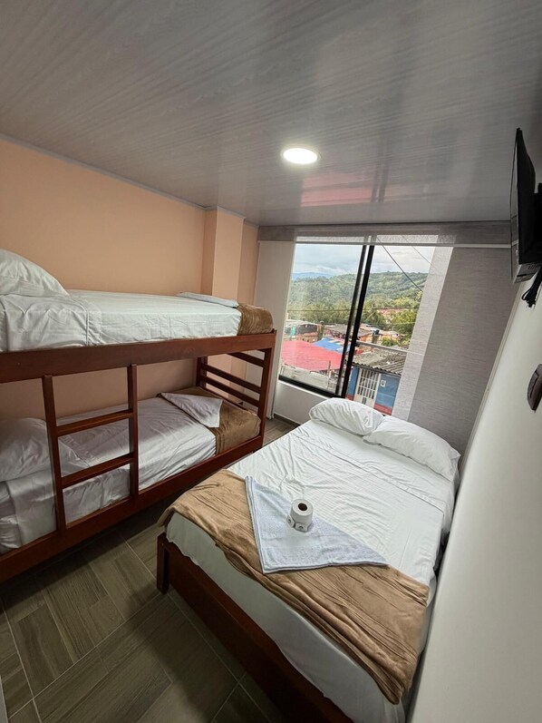 Una habitación con literas, una ventana con vistas y una lámpara en el techo.