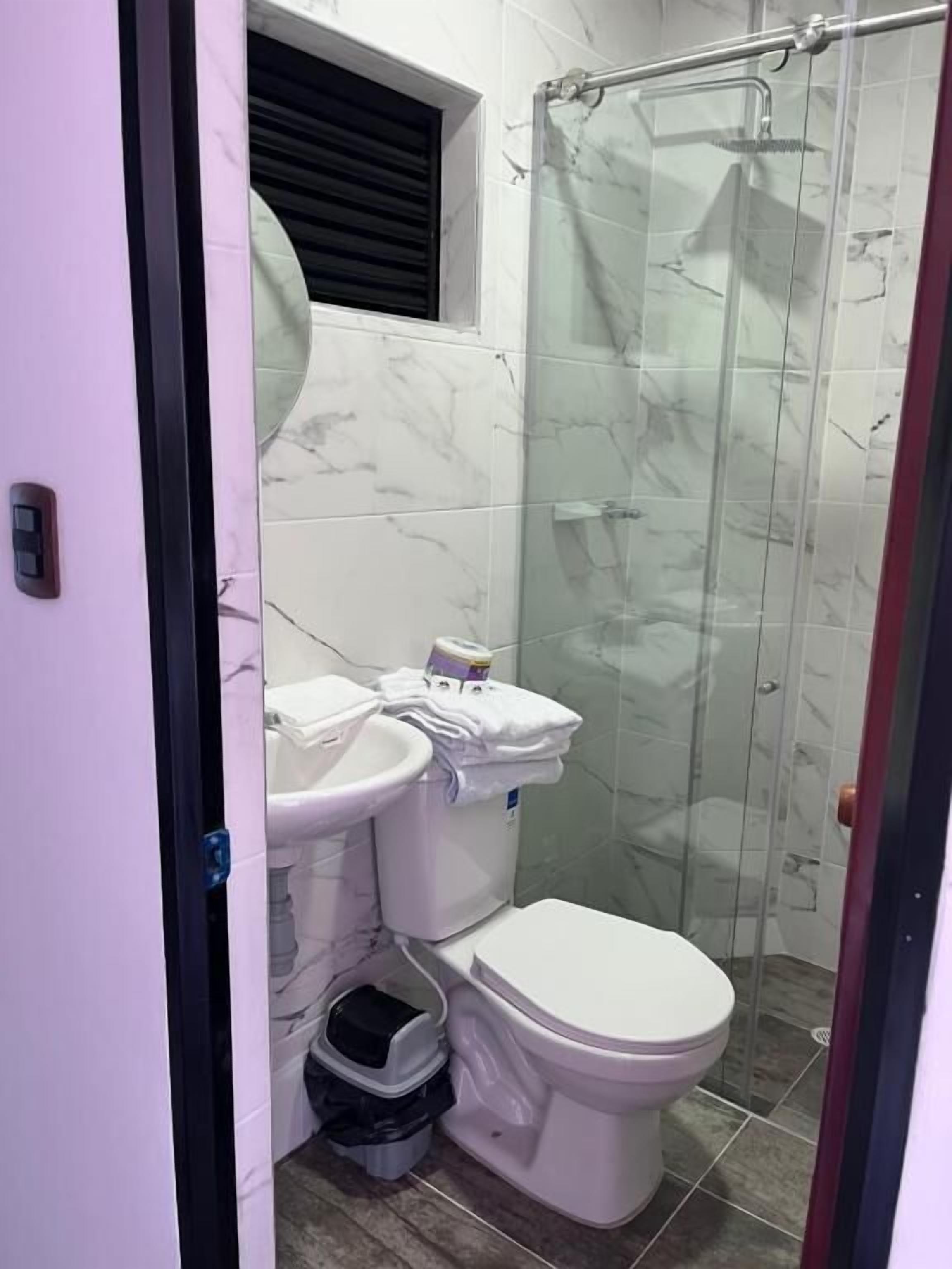 Un baño con inodoro, bidé y cabina de ducha.