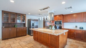 Una cocina moderna con armarios de madera, electrodomésticos de acero inoxidable y una isla central.