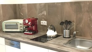 A kitchen with a toaster, coffee maker, kettle, and utensils on the counter. - Apartment for 4 Guests, 55 m², with Wi-Fi (Berlin)