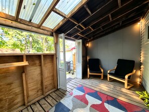 A covered porch with a wooden bench, a door leading outside, and a patterned rug. - Modern Cottage Near Beaches Subway Free Private Parking (Toronto)