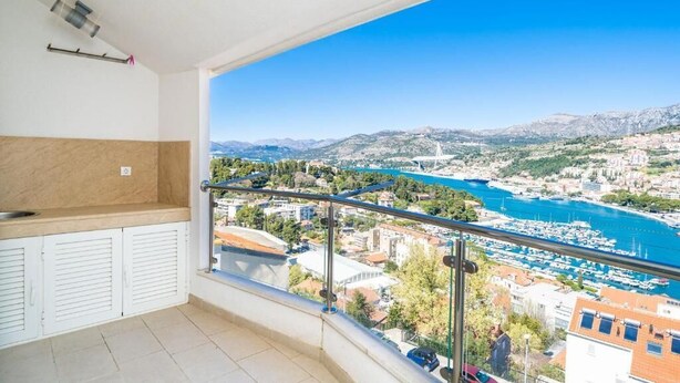 Ein Balkon mit Blick auf einen Yachthafen und Berge.