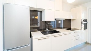 Eine moderne Küche mit Einbaukühlschrank, einer Spüle und einer Dunstabzugshaube.