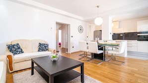 Ein modernes Wohnzimmer mit Sofa, Couchtisch und Essbereich.