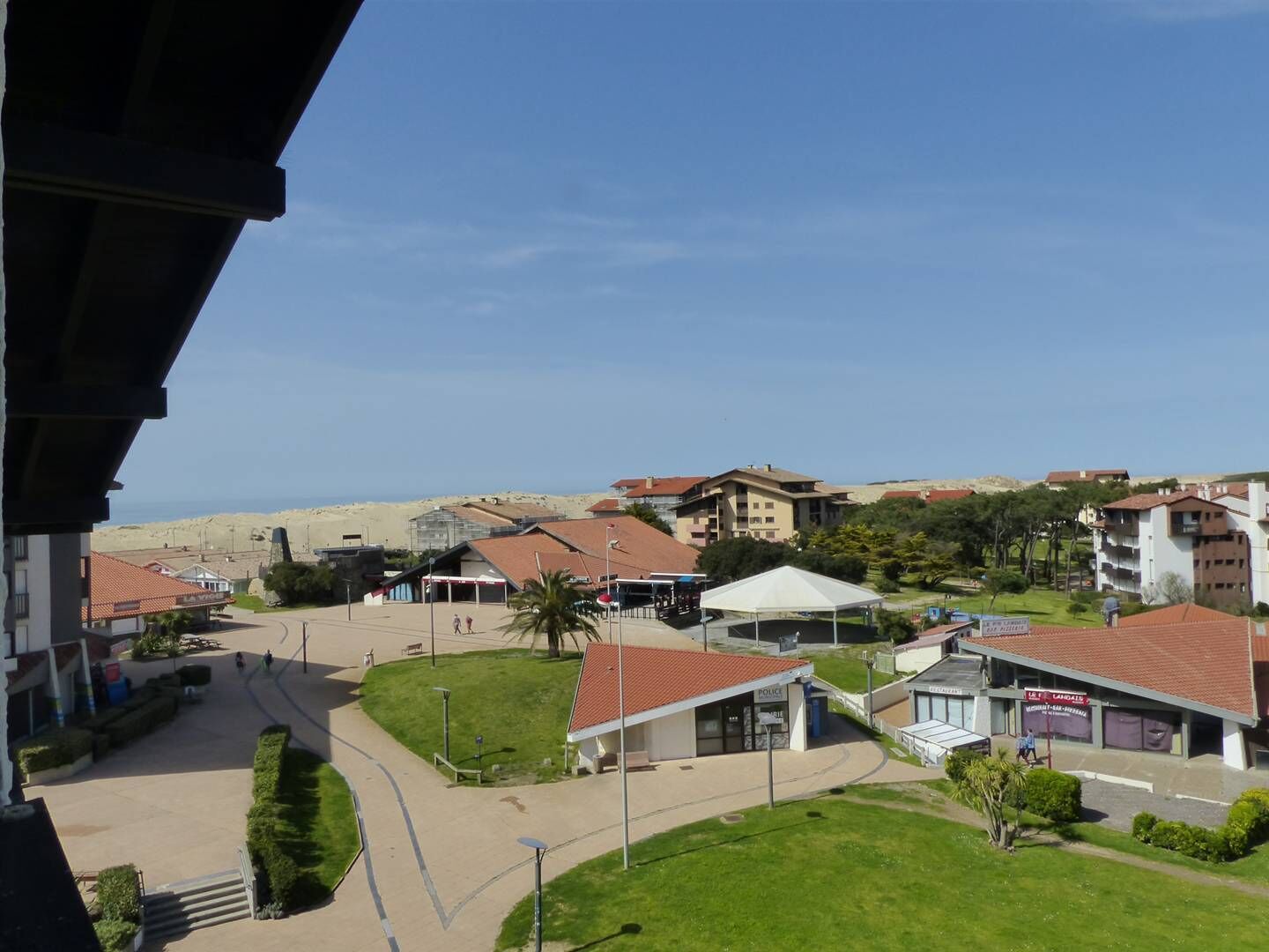 A coastal town with buildings, a police station, and a beach in the background.