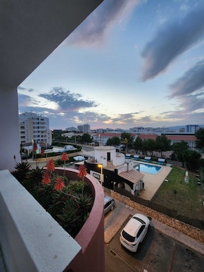 Un quartier résidentiel avec une piscine, une voiture garée à proximité et un bâtiment portant l’inscription « TERRASSE ».