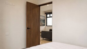 A bedroom with a bed, a wooden door, a window, and a view of mountains. - Dept. Central Location | Fast Wi-Fi | 2 Bedrooms | Val'Quirico (San Martín Texmelucan de Labastida)
