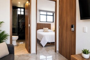 Une chambre d’hôtel moderne équipée d’un lit, d’une douche, de toilettes et d’un téléviseur.