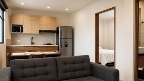 A compact living space with a kitchenette, a sofa, a dining table, and a bed. - Dept. Central Location | Fast Wi-Fi | 2 Bedrooms | Val'Quirico (San Martín Texmelucan de Labastida)
