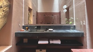 Ein Badezimmer mit großem Spiegel, Waschbecken und Handtuchhalter.