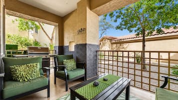 Un espace patio aménagé avec du mobilier d’extérieur, un ventilateur de plafond et une vue sur la rue.