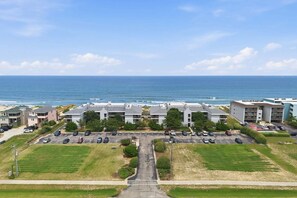 Hotel a la costa amb diversos edificis, aparcaments i vistes a l'oceà.