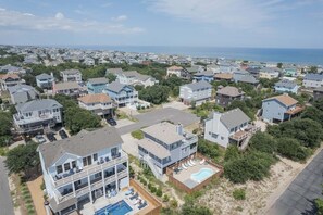 A residential area with houses, a swimming pool, and a view of the ocean. - 1725 - Sunshine and Whiskey 4BR oceanside retreat with private pool, hot tub, and deck access. (Corolla)