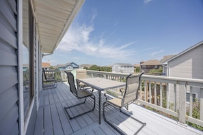 A wooden deck with a table and chairs, overlooking a residential area. - 1725 - Sunshine and Whiskey 4BR oceanside retreat with private pool, hot tub, and deck access. (Corolla)