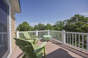 A wooden deck with a white railing, two green Adirondack chairs, and a small table. - 1925 - Lemon Cooler Your Corolla dream stay: 6BR, pool, hot tub, theater room & sunny decks. (Corolla)