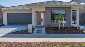 Ein modernes Einfamilienhaus mit Garage, Eingangstür und kleinem Garten.