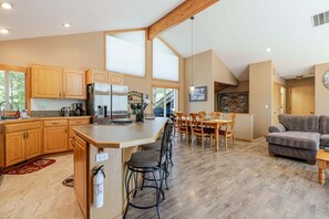 Una cocina amplia con armarios de madera, una isla central y un comedor con mesa y sillas.