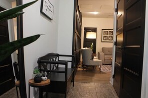 Um corredor com sala de jantar, sofá e geladeira.