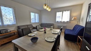Ein modernes Wohnzimmer mit Esstisch, Sofas und einem Radio.