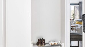 Ein Schrank mit Kleiderhaken und Ablagen für Schuhe.