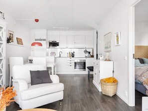 Um espaço compacto com cozinha compacta, sofá, área de refeições e cama.
