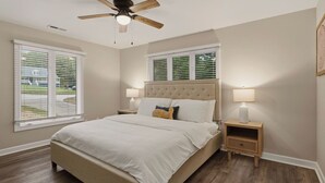A bedroom with a large bed, two bedside tables, a ceiling fan, and windows with blinds. - Poolside Paradise by Avantstay Waterfront Home + Pool + Spa Dock + Game Room Near Hiking (Sherrills Ford)