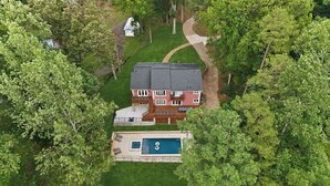 An aerial view of a two-story house with a swimming pool, surrounded by trees. - Poolside Paradise by Avantstay Waterfront Home + Pool + Spa Dock + Game Room Near Hiking (Sherrills Ford)