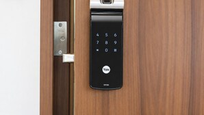Una cerradura inteligente Yale YDF40A instalada en una puerta de madera.