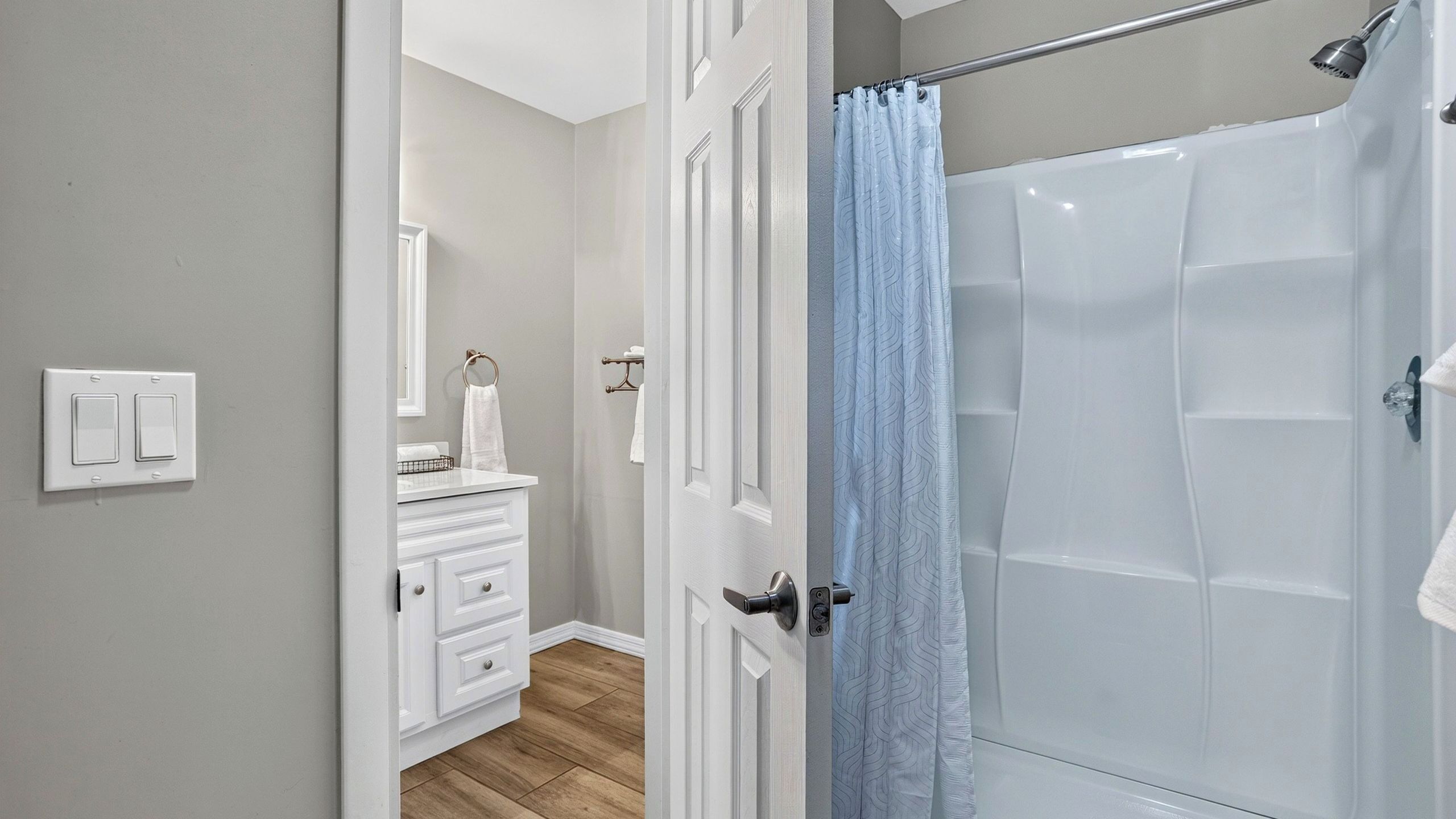 A bathroom with a shower, a toilet, a sink, and a mirror.
