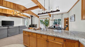 A modern kitchen with wooden beams, a marble countertop, and a built-in stove. - Ute Cabin by Avantstay Vintage Cabin + BBQ Deck Ski Donner Summit + Lake + Truckee (Truckee)