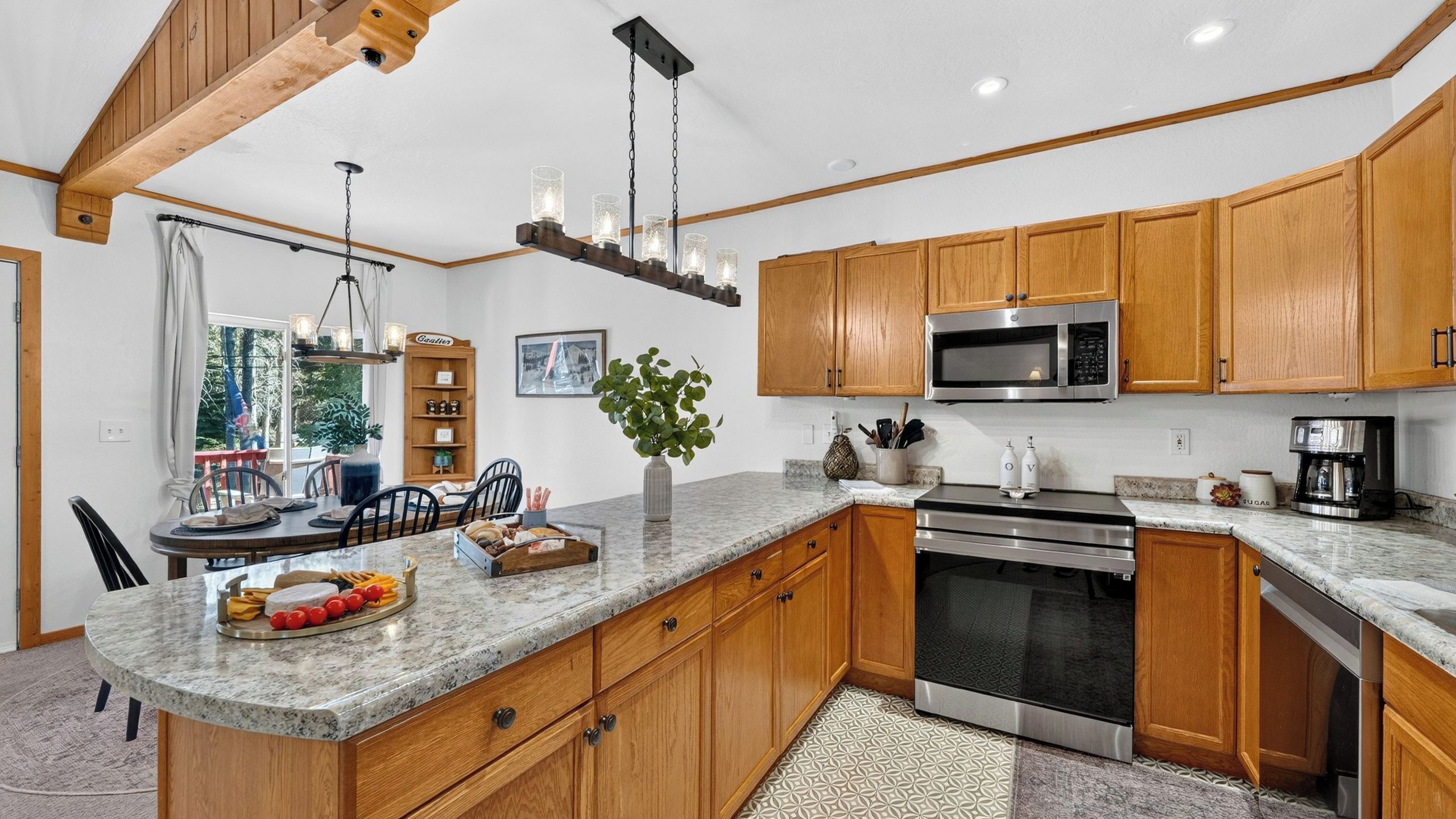 A modern kitchen with wooden cabinets, a stainless steel oven, and a granite countertop.