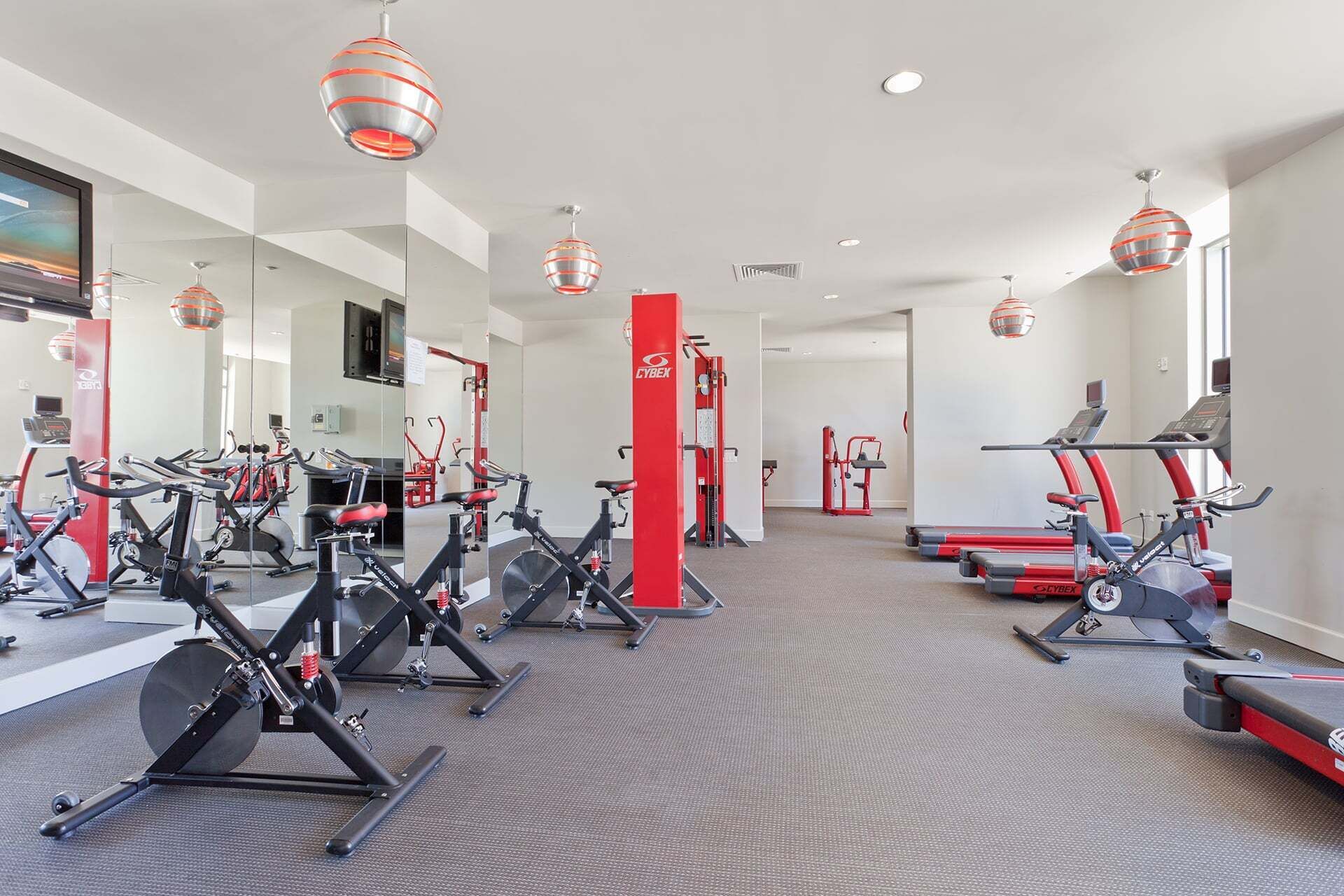 Una palestra con cyclette, tapis roulant e macchinari per pesi.