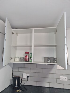 A kitchen with a white cabinet, a kettle, and a coffee maker on the counter. - City Centre, En-Suit double room-6, City View Place (Cambridge)