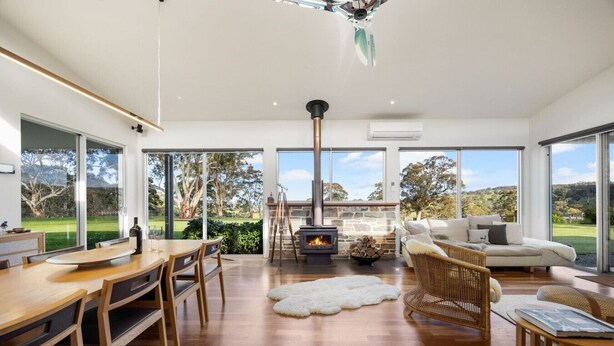 Ein modernes Interieur mit Essbereich, Kamin und einer Sitzecke mit Blick ins Freie.