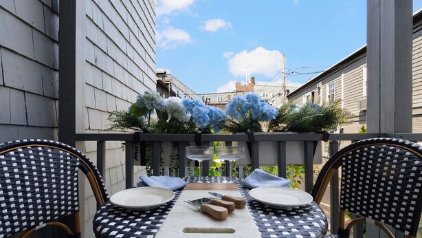 Eine Terrasse im Freien mit einem Tisch für zwei Personen, ausgestattet mit Schneidebrett, Messern und Tellern.