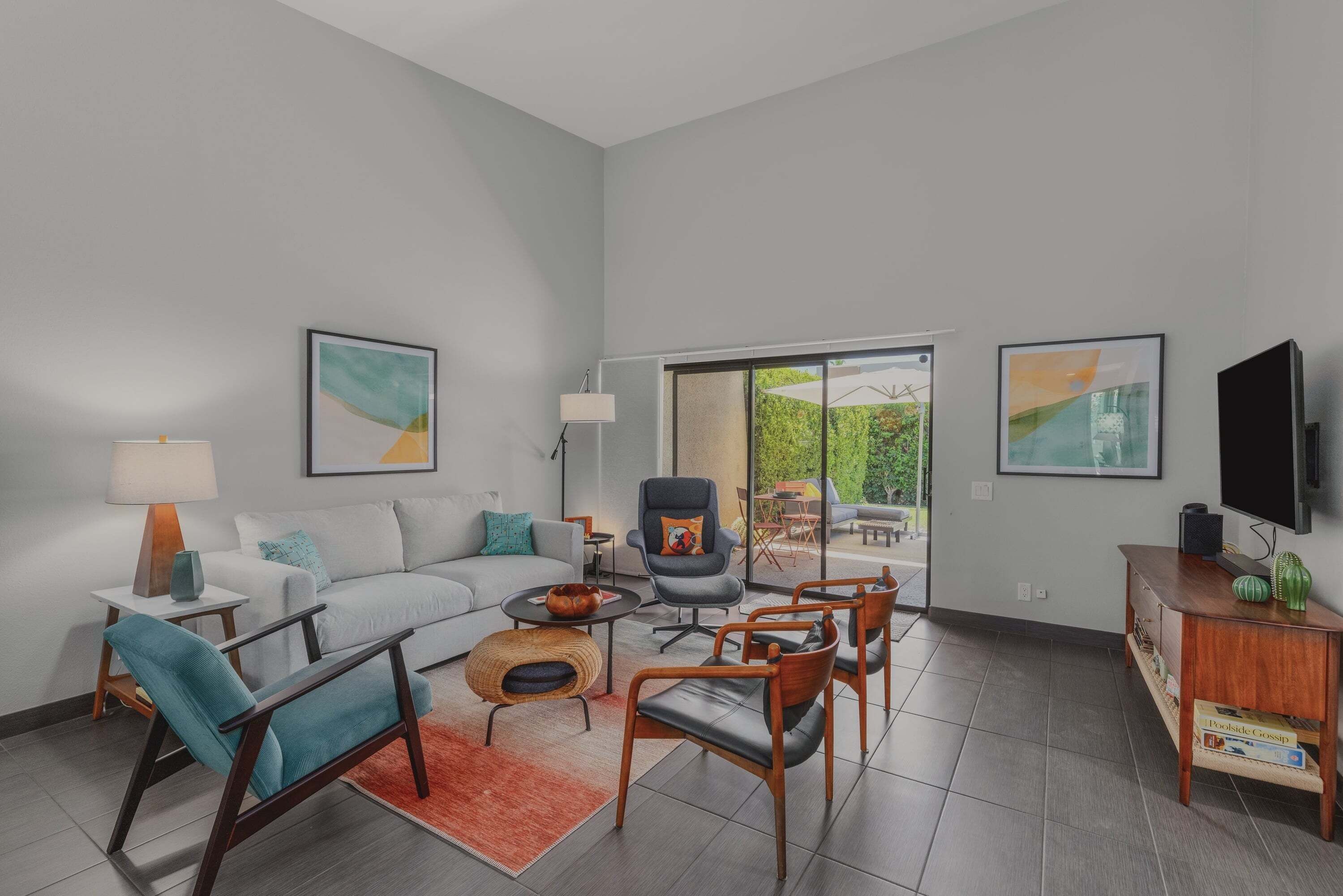 A modern living room with a sofa, chairs, a coffee table, and artwork on the walls.