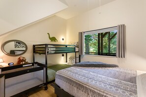A bedroom with bunk beds, a desk, a mirror, and a window with a view of trees. - San Moritz Lake House | Walk to Lake Gregory | 3BR (Crestline)
