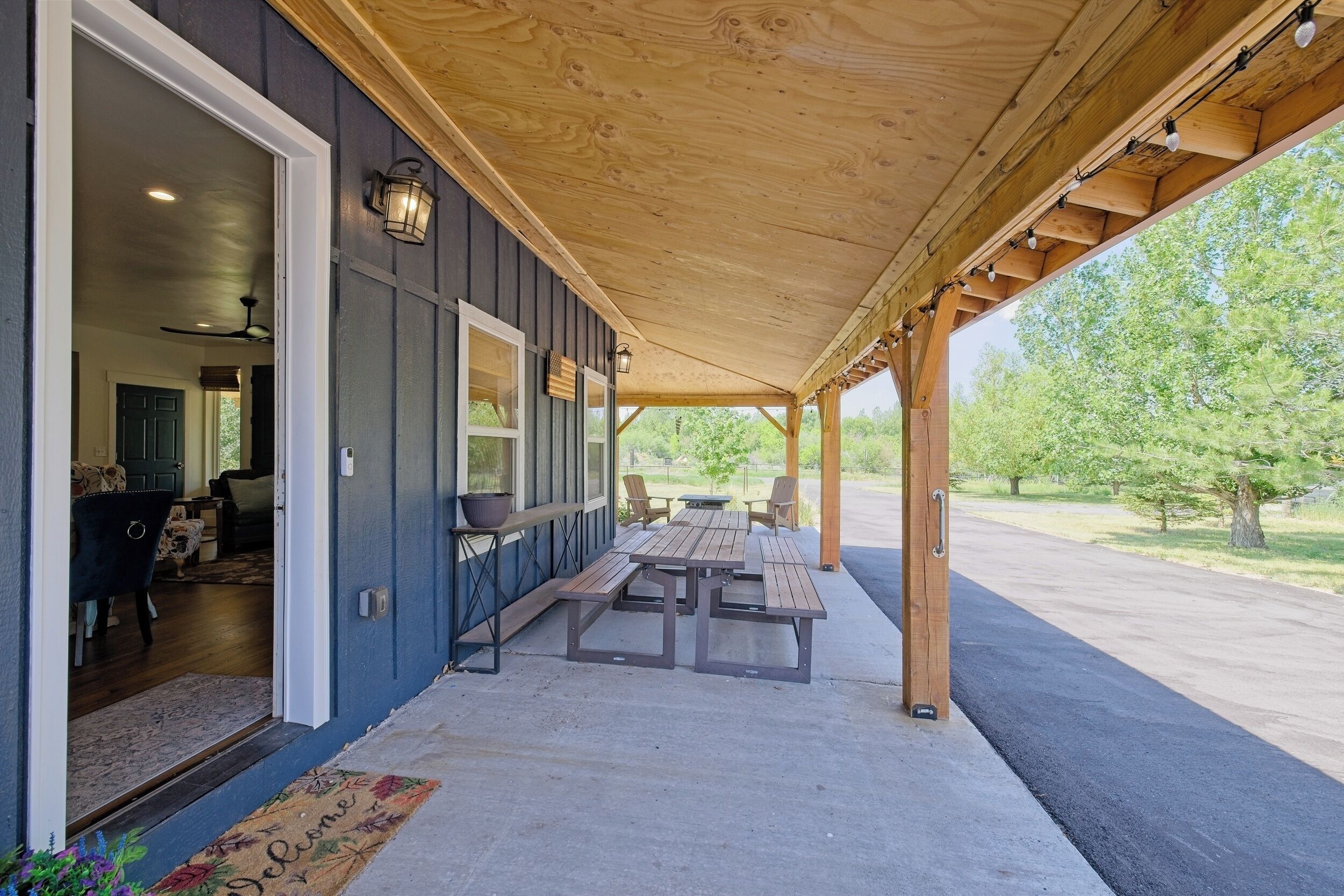 Une terrasse couverte avec des poutres en bois, un banc et une table.