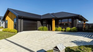 A modern two-story house with a garage, a driveway, and a mailbox. - Spacious Taupō Home - Arcade, Games, Walk to Lake (Taupō)