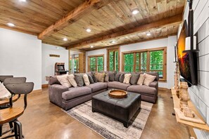 Ein modernes Wohnzimmer mit einer Eckcouch, einem Couchtisch und einem Fernseher.