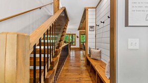 A wooden staircase leading to a room with a bench and a sign indicating WiFi availability. - Maison Bleue - Close to Downtown | Game Room | Firepit (Blue Ridge)