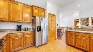 A kitchen with wooden cabinets, stainless steel appliances, and a tiled floor. - Las Brisas: New Rental, Large Private Pool, Hot Tub (Corolla)