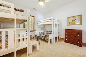 A bunk bed room with a ceiling fan, a dresser, and a framed picture on the wall. - Las Brisas: New Rental, Large Private Pool, Hot Tub (Corolla)